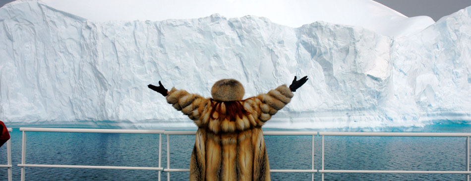 Woman joyful with arms open as the ship passes a Glacier